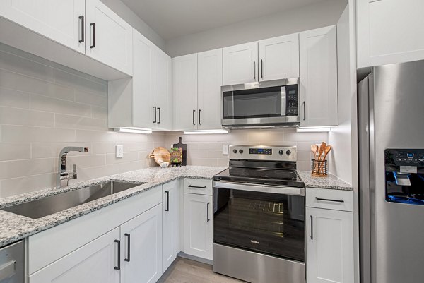 Modern kitchen with stainless steel appliances at Alta Denton Station Apartments