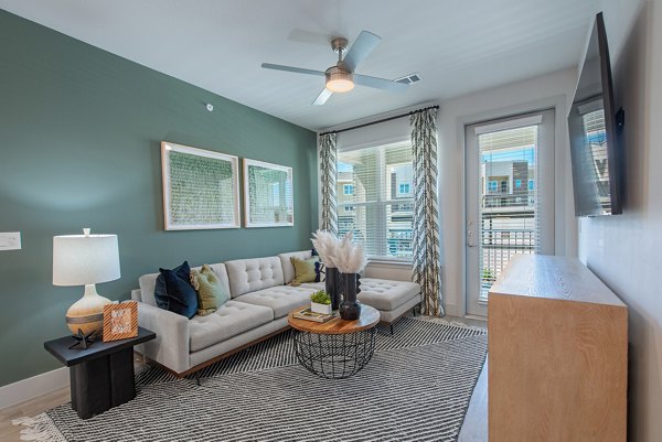 Modern living room with sleek furnishings and large windows at Alta Denton Station Apartments