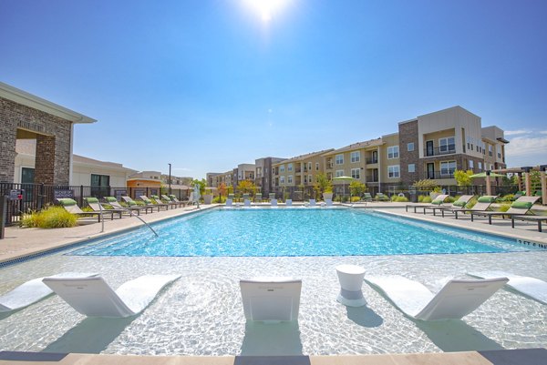 Resort-style pool with sundeck at Alta Denton Station Apartments offering luxury relaxation
