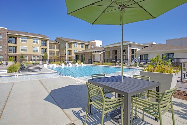 Resort-style pool with lounge chairs at Alta Denton Station Apartments, offering luxury living in a vibrant community