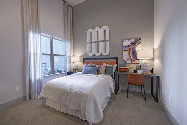 Luxurious bedroom with modern decor and ample natural light at Alta at the Farm Apartments