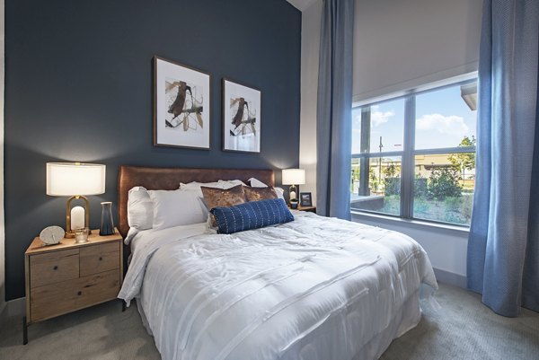 Cozy bedroom with modern decor at Alta at the Farm Apartments, offering luxury living in a tranquil environment for residents
