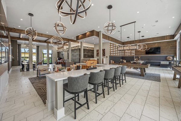 Clubhouse with modern design and cozy seating at Alta at the Farm Apartments, ideal for gatherings and relaxation in Greystar's luxury community