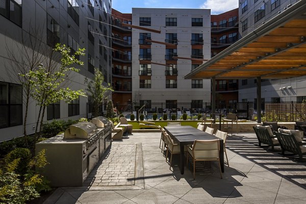 Outdoor grill area with modern seating at Alta Federal Hill Apartments, featuring state-of-the-art barbeque facilities for residents