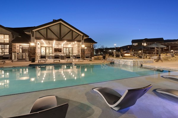 Alta Green Mountain Apartments: Outdoor pool with poolside lounge chairs and garden views, luxurious living experience in Lakewood, CO.