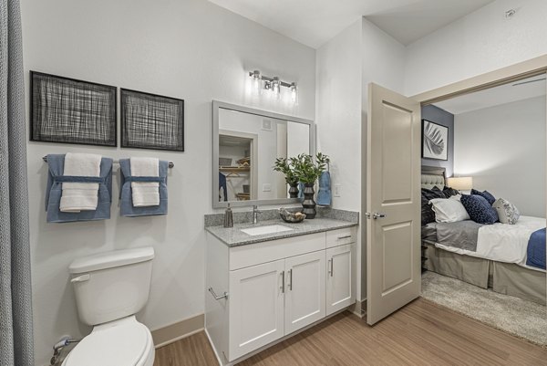 Contemporary bathroom with double vanity and large mirror at Alta Landing Apartments