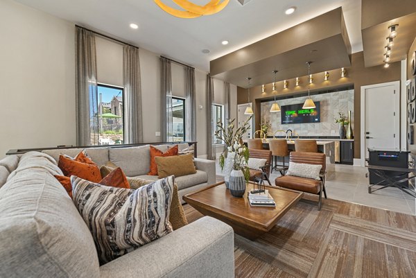 Modern clubhouse with comfy seating and large screen TV at Alta Landing Apartments