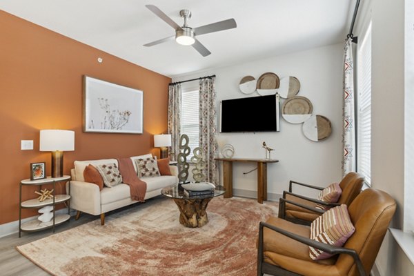 Spacious living room with modern decor and large windows in Alta Marine Creek Apartments