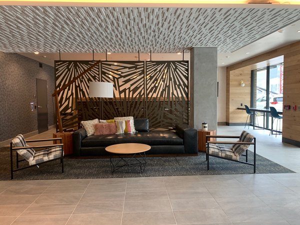 Clubhouse with modern decor at Alta Peak Apartments featuring a lounge area and meeting spaces for residents