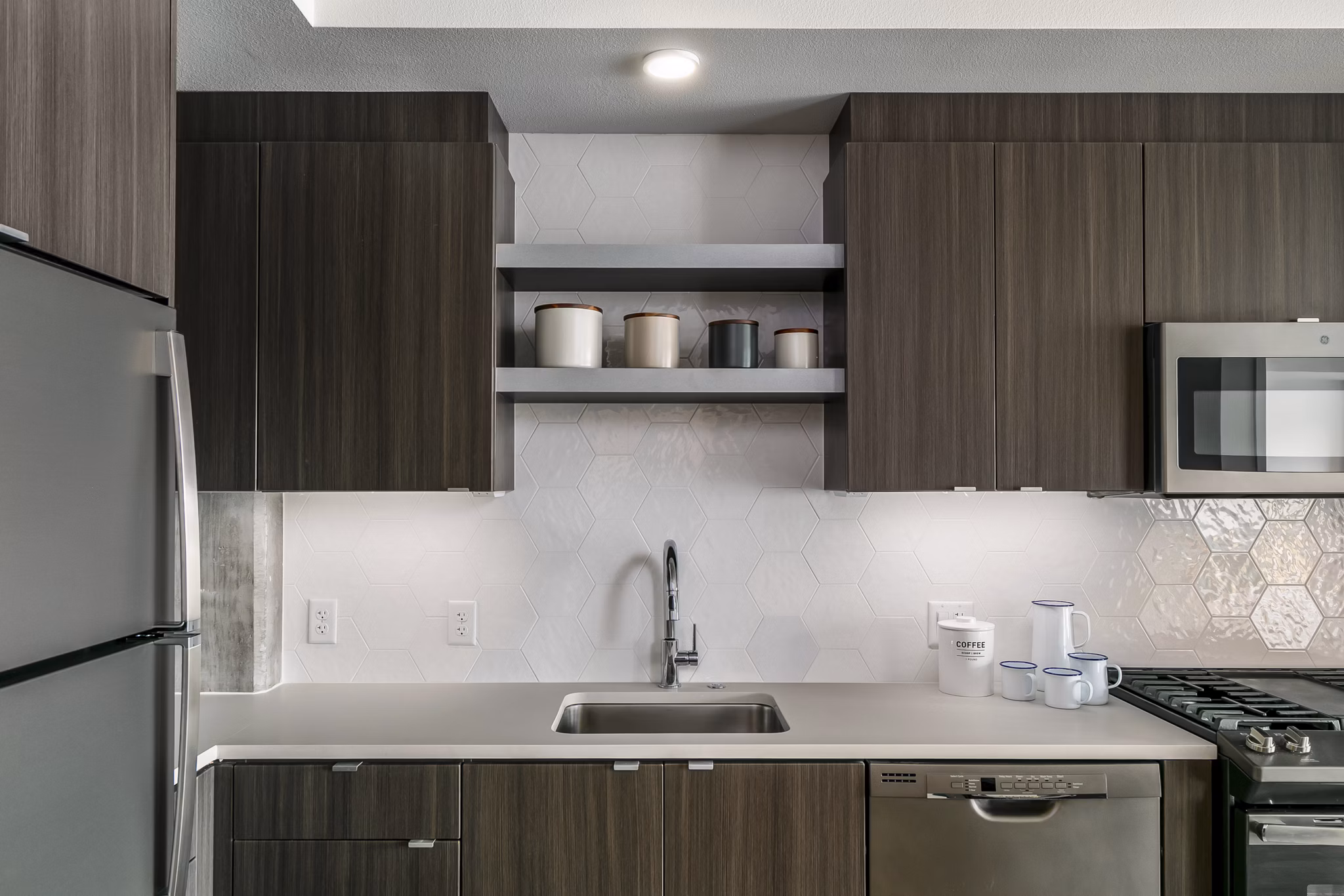 Modern kitchen with stainless steel appliances at Alta Peak Apartments, offering luxurious living spaces