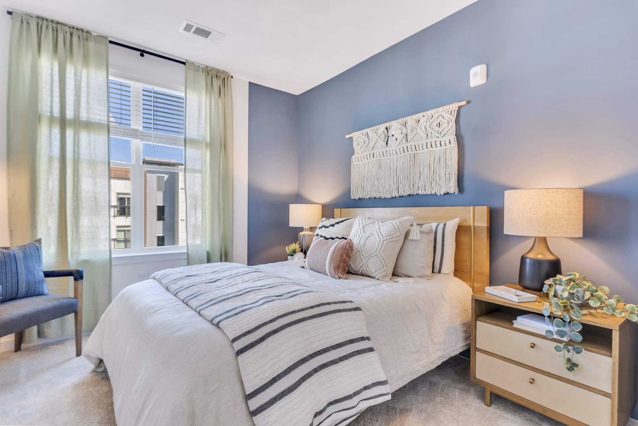 Modern bedroom with minimalist decor at Alta Purl Apartments, featuring luxurious king bed and industrial-style lighting