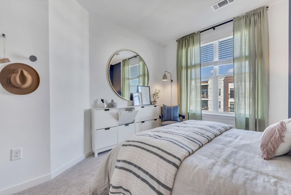 Modern bedroom with sleek decor and large windows at Alta Purl Apartments, luxury living by Greystar in vibrant urban location