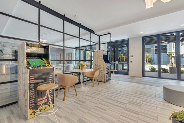 Game room with billiards table and lounge seating at Alta Purl Apartments