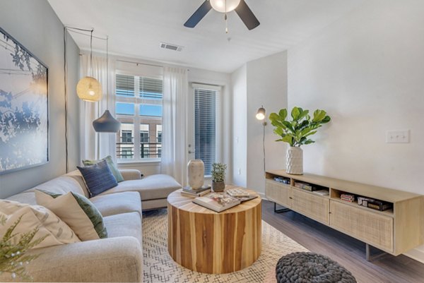 Living room with modern furnishings and expansive windows at Alta Purl Apartments, a luxury property offered by Greystar