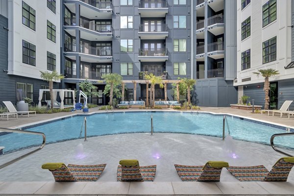 Inviting pool area with modern lounge chairs at Alta Purl Apartments, a Greystar luxury apartment community