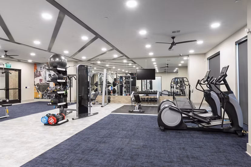 State-of-the-art fitness center with cardio machines and weights at Alta River Oaks Apartments