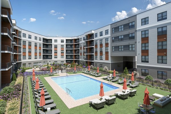 Inviting pool area at Alta on the Row Apartments featuring lounge chairs and modern design