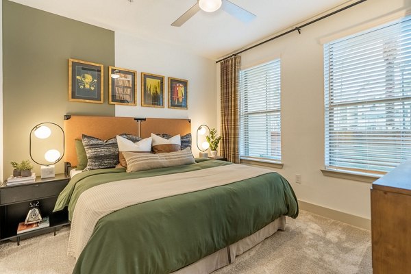 Cozy bedroom with modern furnishings at Alta Sergeant Apartments, offering luxury living spaces within the Greystar community