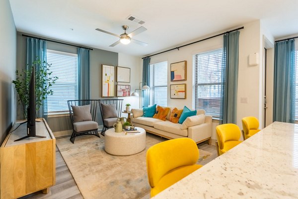 Modern living room with sleek furnishings at Alta Sergeant Apartments, featuring large windows and open layout