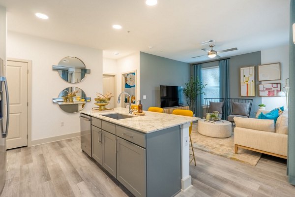 Spacious living room with modern dÃ©cor and large windows in Alta Sergeant Apartments Perfect for luxury living near city conveniences