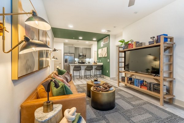 Living room with modern furnishings and sleek design at Alta Sergeant Apartments Luxurious Greystar community
