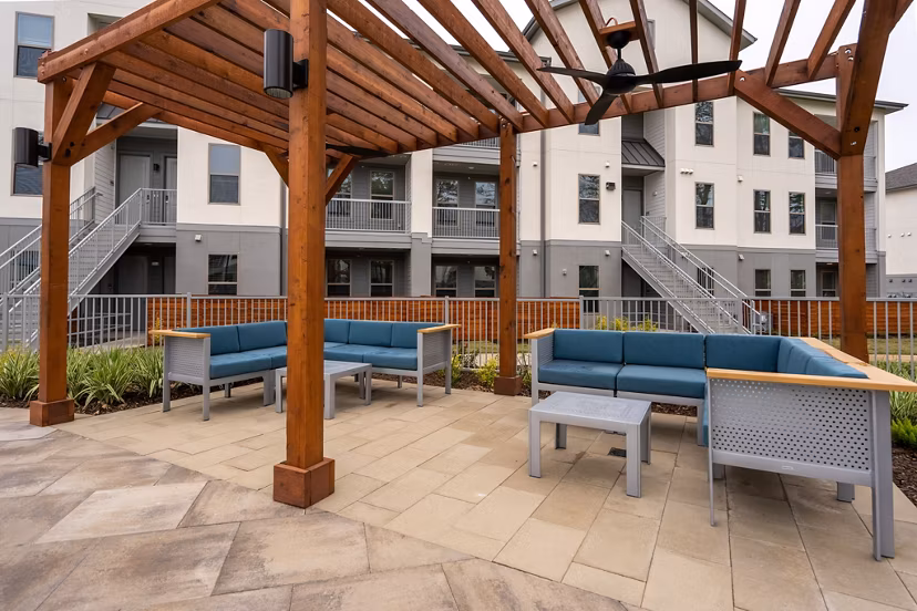 Patio with modern seating and lush landscaping at Alta Sergeant Apartments