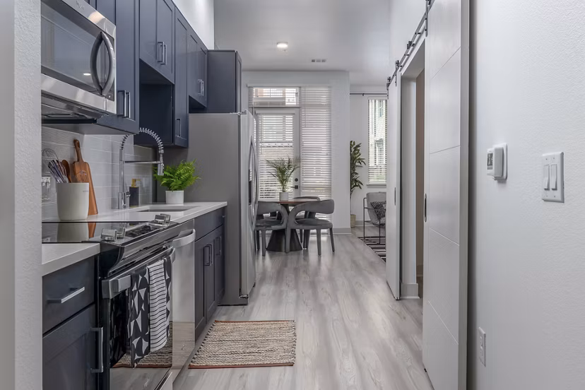 Modern kitchen with sleek appliances and granite countertops at Alta Sloan's Lake apartments