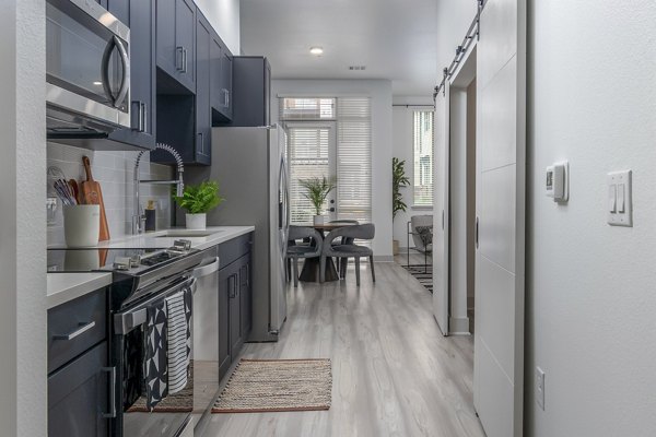 Modern kitchen with sleek appliances and granite countertops at Alta Sloan's Lake apartments
