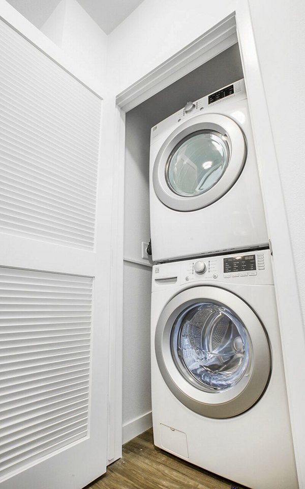Laundry room with modern washers and dryers at Alta South Bay Apartments, offering residents convenient and efficient laundry facilities