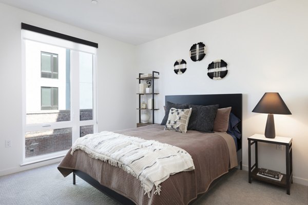 Cozy bedroom with modern decor and large windows at Alta Star Harbor Apartments, a luxury living community