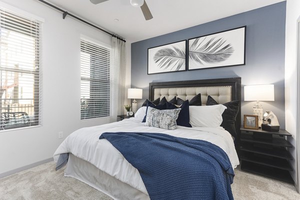 Elegant bedroom at Alta Surprise Apartments with modern decor and plush bedding, offering luxury living experience in vibrant surroundings