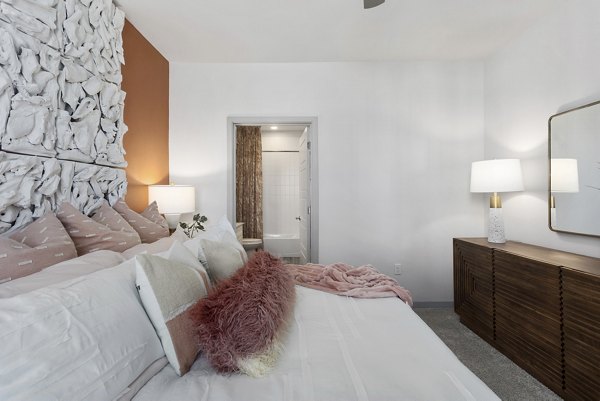 Elegant bedroom with modern furnishings and large windows in Alta Surprise Apartments