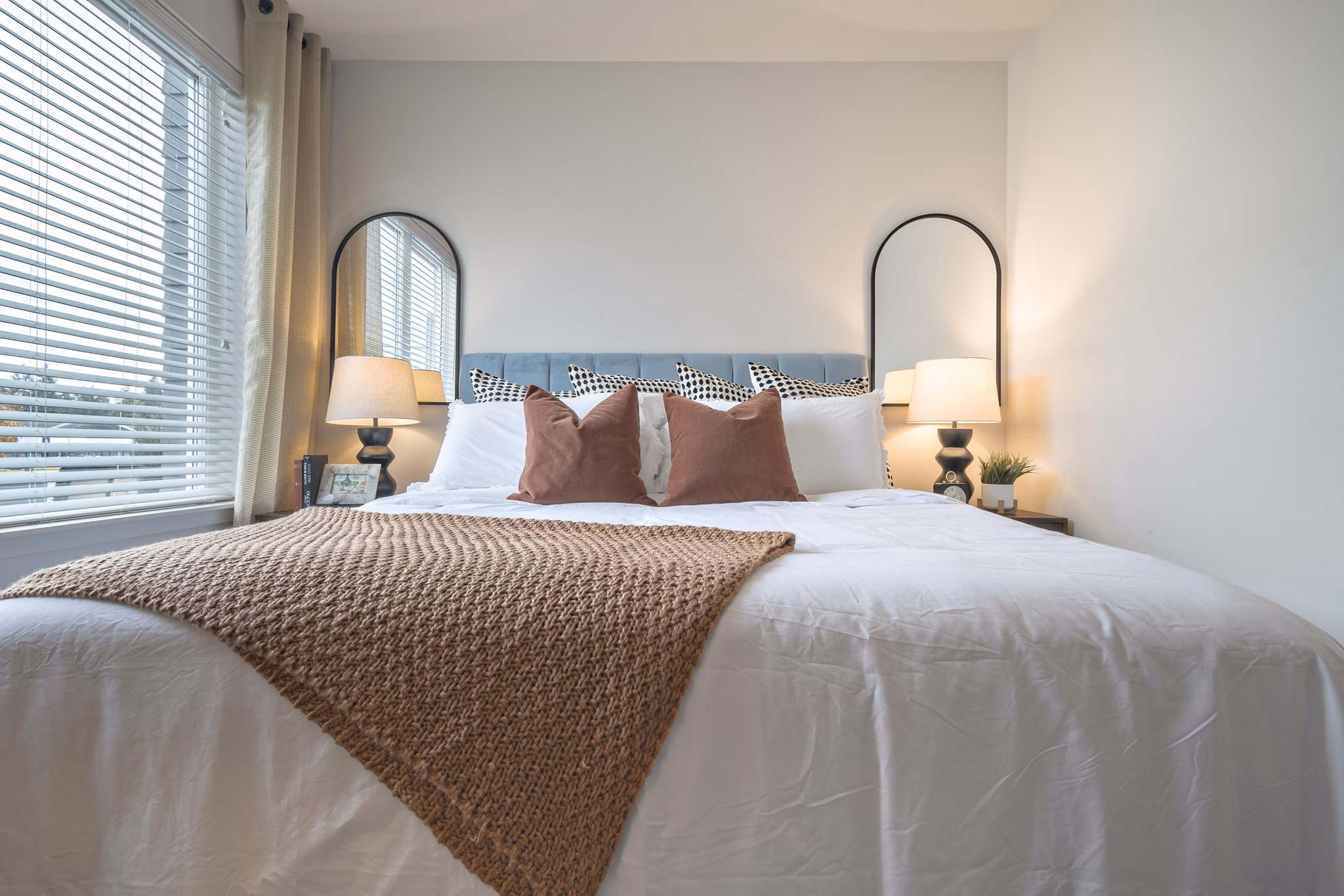 Cozy bedroom with modern decor at Alta University Place Apartments, featuring luxurious bedding and spacious layout