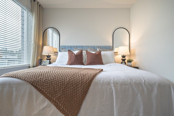 Cozy bedroom with modern decor at Alta University Place Apartments, featuring luxurious bedding and spacious layout