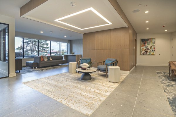 Clubroom featuring modern seating and communal tables at Alta University Place Apartments