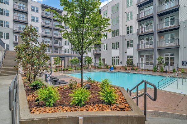 Sparkling pool with lounge chairs at Alta West Morehead apartments, perfect for relaxation and leisure time in a luxury setting