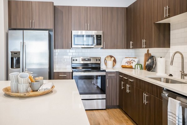 Modern kitchen with stainless steel appliances at Alta Wren Apartments, a Greystar luxury community
