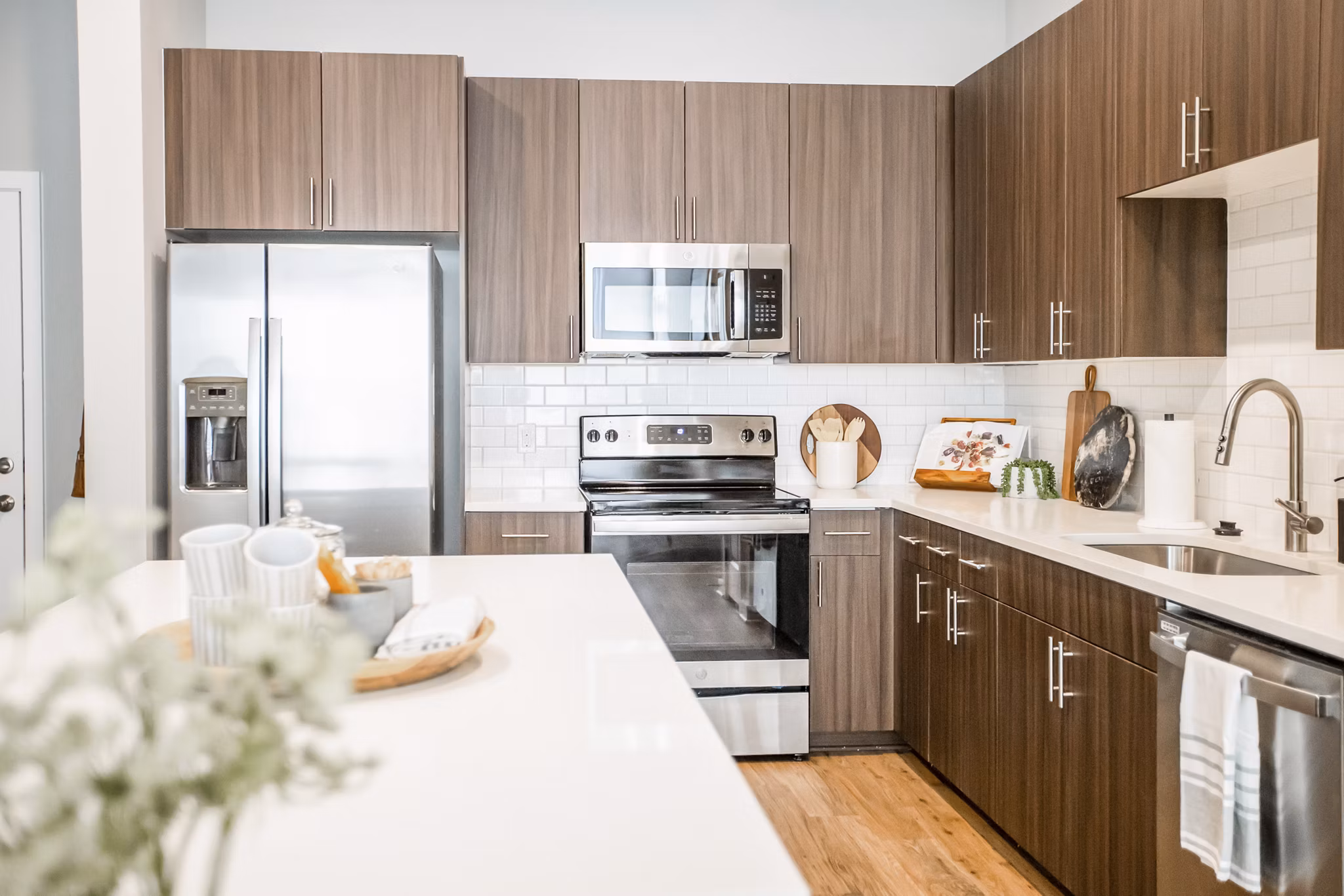 Modern kitchen with quartz countertops and stainless steel appliances in Alta Wren Apartments