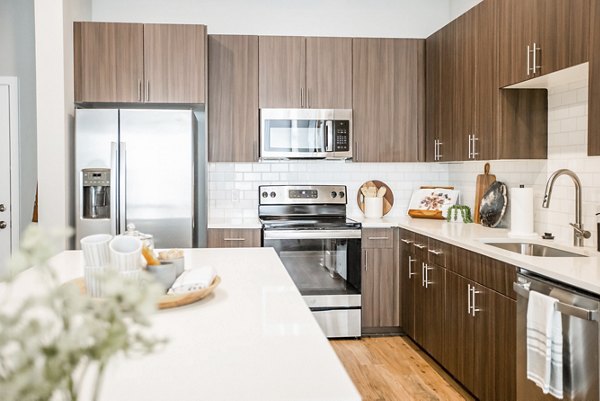 Modern kitchen with quartz countertops and stainless steel appliances in Alta Wren Apartments