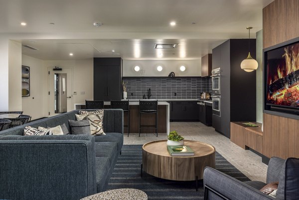 Living room with modern decor and large windows at The Brady Apartment in Dallas, offering a luxurious urban lifestyle experience
