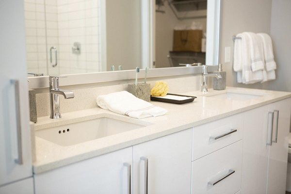 Elden Galleria Apartments: Modern bathroom featuring sleek fixtures and elegant tiling in luxury setting