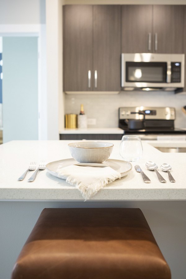 Dining area with sleek furniture and modern lighting at Elden Galleria Apartments in a luxurious Greystar community