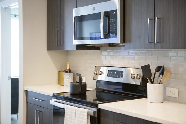 Modern kitchen with sleek countertops and stainless steel appliances in Elden Galleria Apartments
