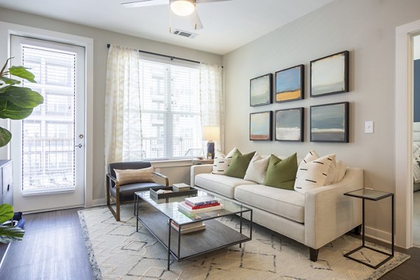 Living room featuring modern furnishings and large windows at Elden Galleria Apartments, luxury living in a vibrant community