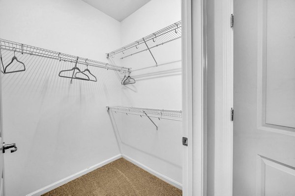 Walk-in closet with ample shelving in Fox Hunt Farms Apartments' luxury bedroom