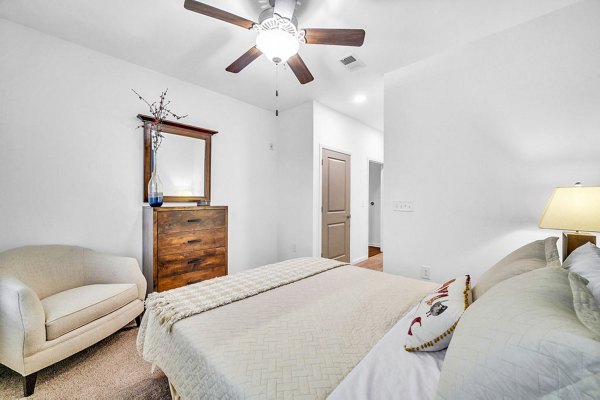 Cozy bedroom with modern furnishings in Fox Hunt Farms Apartments, Greystar luxury living