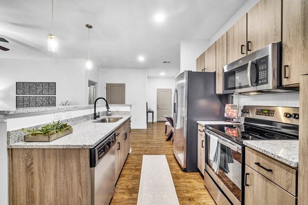 Modern kitchen with granite countertops and stainless steel appliances at Fox Hunt Farms Apartments