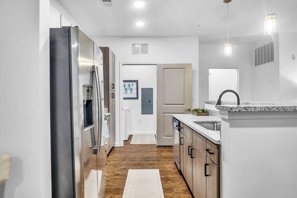 Modern kitchen with stainless steel appliances at Fox Hunt Farms Apartments in Greystar community, offering luxurious living spaces