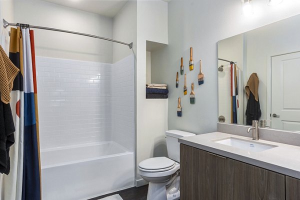 Modern bathroom with sleek fixtures and large mirror at Jefferson Cenza Apartments