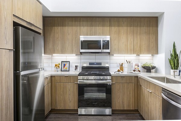 Modern kitchen with stainless steel appliances at Jefferson Cenza Apartments